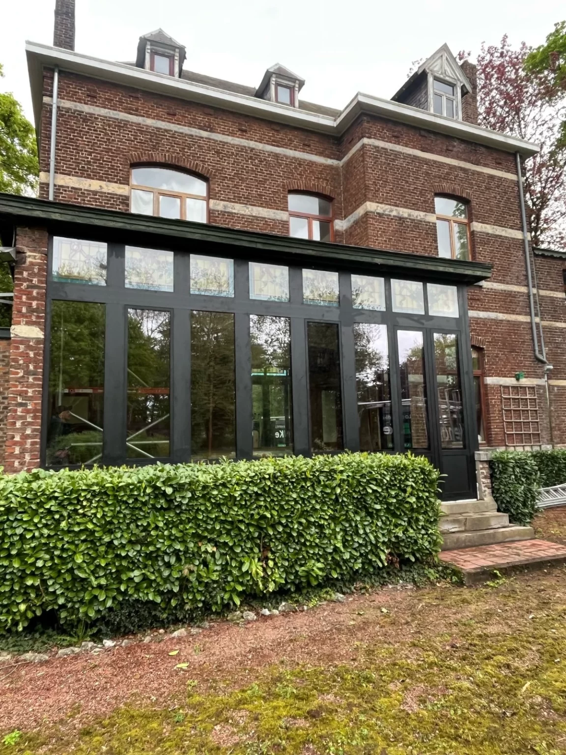 echnicien effectuant un dépannage de vitrage sur fenêtre en PVC et le remplacement de la vitre embuée en Belgique.